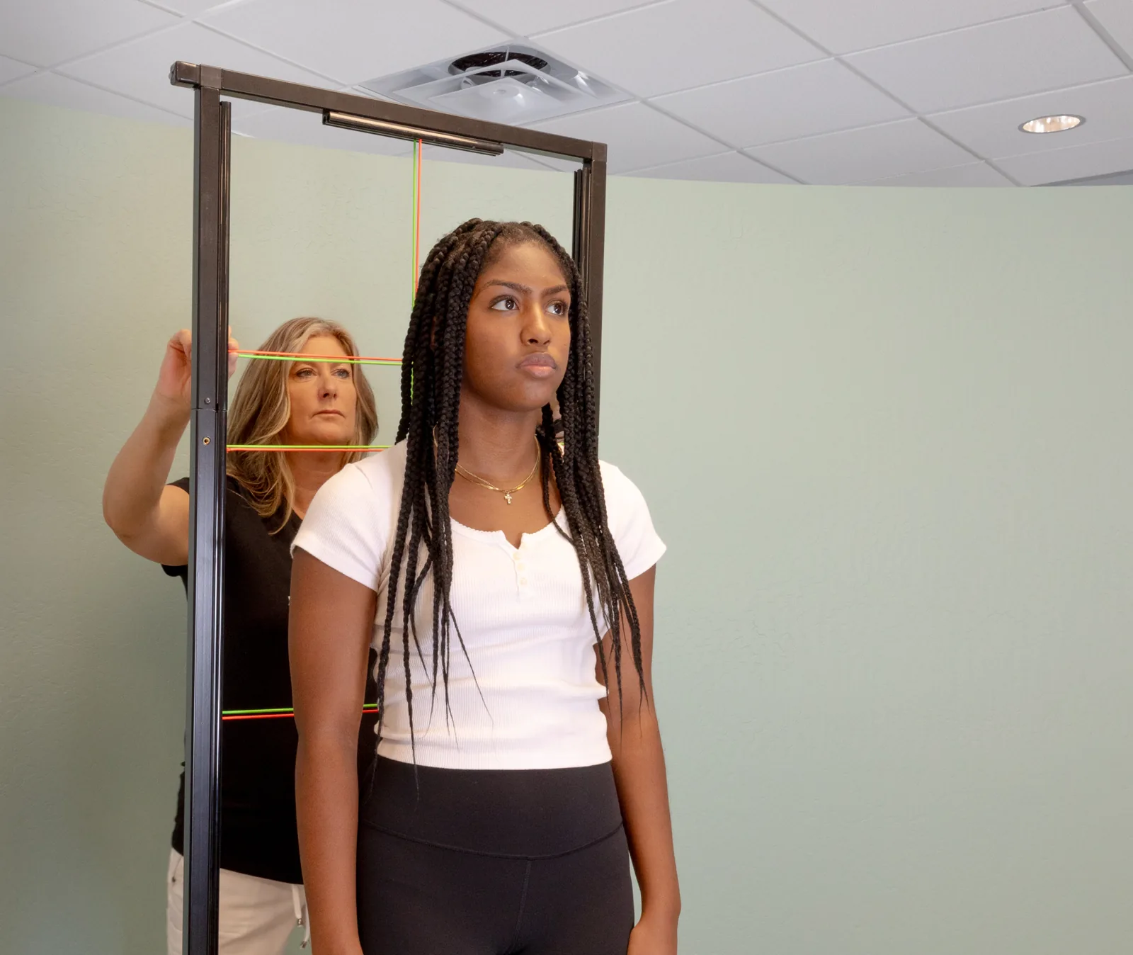 Dr. Tracey Ryder checking a patient's posture and spinal alignment before an adjustment at Ryder Chiropractic in Scottsdale